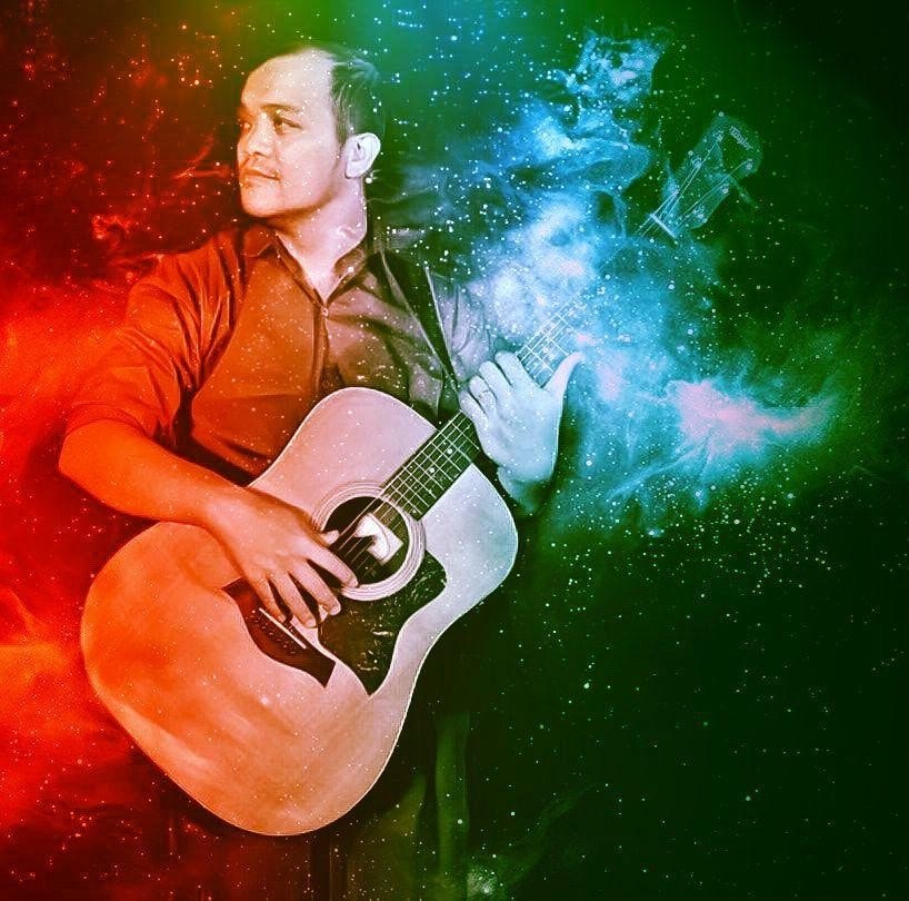 Malbert playing acoustic guitar